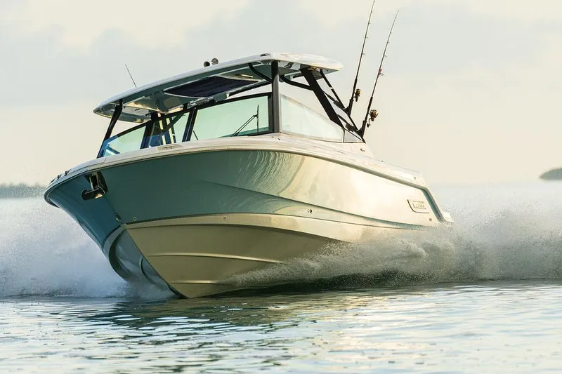 Slide: The Image of Manufacturer Provided Image: 2026 Boston Whaler 330 Vantage cruising on water, showcasing sleek design and fishing rods. - 2
