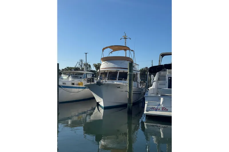 The Image of 1986 Newburyport 37 boat docked in a marina under clear blue sky. - 1