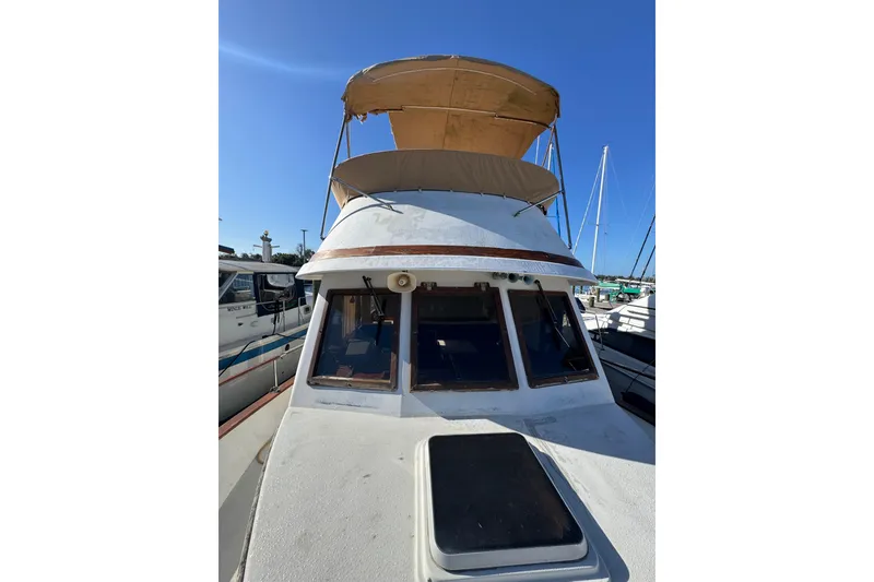 Slide: The Image of 1986 Newburyport 37 boat with canopy, docked under clear blue sky. - 11