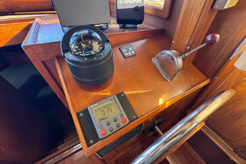 Slide: The Image of 1986 Newburyport 37 boat cockpit with compass, throttle, and navigation equipment. - 14