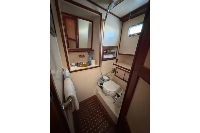 Slide: The Image of Compact 1986 Newburyport 37 boat bathroom with toilet, sink, and shower. - 19