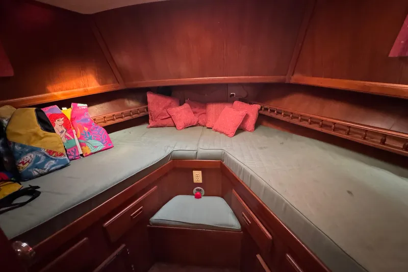 Slide: The Image of Cozy cabin interior of 1986 Newburyport 37 sailboat with cushions and colorful bags. - 20