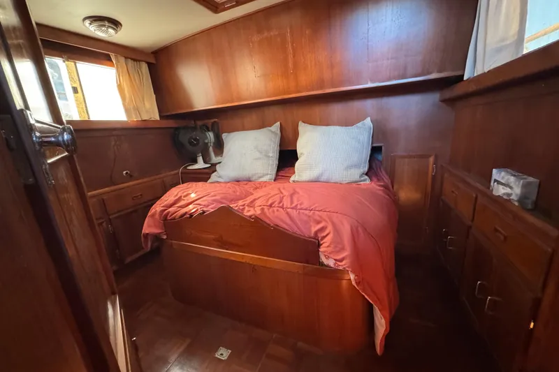 Slide: The Image of Cozy cabin interior of 1986 Newburyport 37 boat with wooden furnishings and bed. - 23