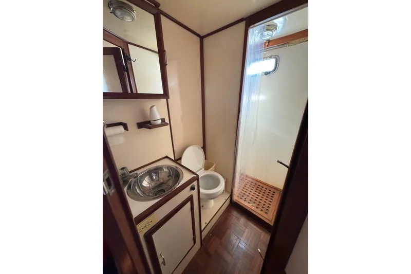 Slide: The Image of Compact bathroom in a 1986 Newburyport 37 boat with sink, toilet, and shower. - 24