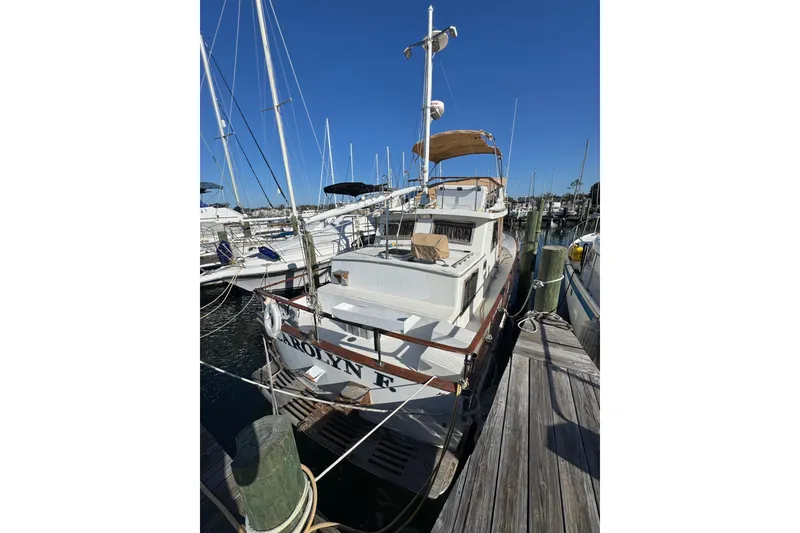 Slide: The Image of 1986 Newburyport 37 boat docked at marina under clear blue sky. - 4