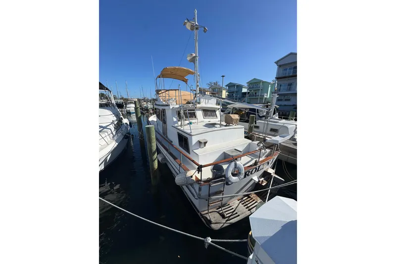 Slide: The Image of 1986 Newburyport 37 boat docked at marina under clear blue sky. - 5