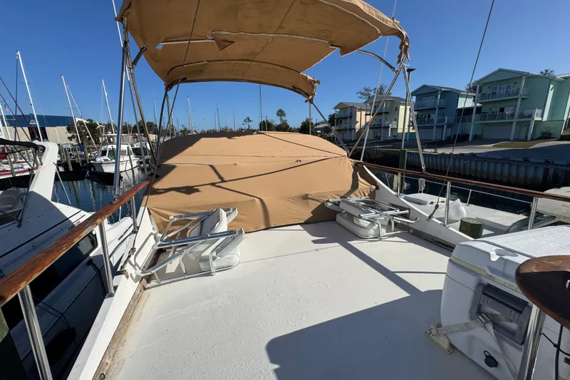 Slide: The Image of 1986 Newburyport 37 yacht deck with canopy, docked at marina under clear blue sky. - 7