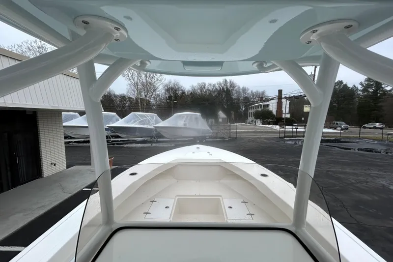 Slide: The Image of 2026 May-Craft 245 Offshore CC boat interior view with covered boats in the background. - 10