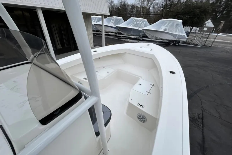 Slide: The Image of 2026 May-Craft 245 Offshore CC boat, spacious deck, parked near covered boats. - 11