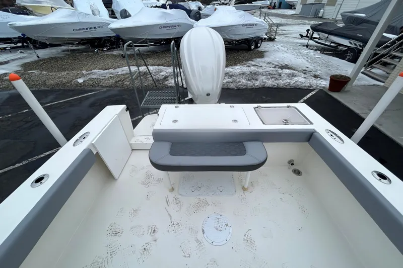Slide: The Image of 2026 May-Craft 245 Offshore CC boat interior with seating and storage, in a snowy marina setting. - 19