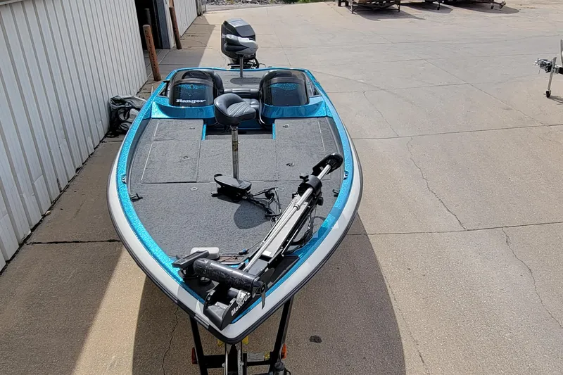 Slide: The Image of 2000 Ranger 522DVX Comanche fishing boat with blue accents, parked on concrete. - 2
