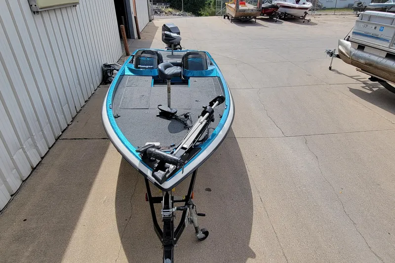 Slide: The Image of 2000 Ranger 522DVX Comanche fishing boat parked on concrete near a building. - 20