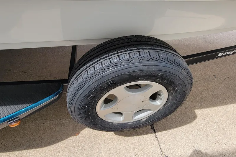 Slide: The Image of Trailer tire of a 2000 Ranger 522DVX Comanche boat on concrete surface. - 4