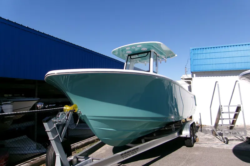 The Image of 2026 Sportsman Open 232 Center Console boat on trailer under clear blue sky. - 0