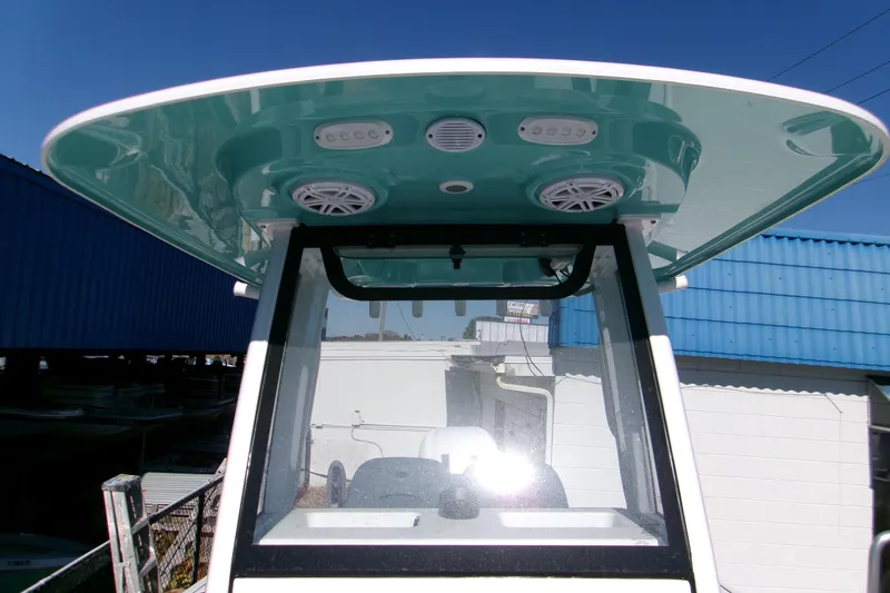 Slide: The Image of 2026 Sportsman Open 232 Center Console boat with teal T-top and speakers. - 12