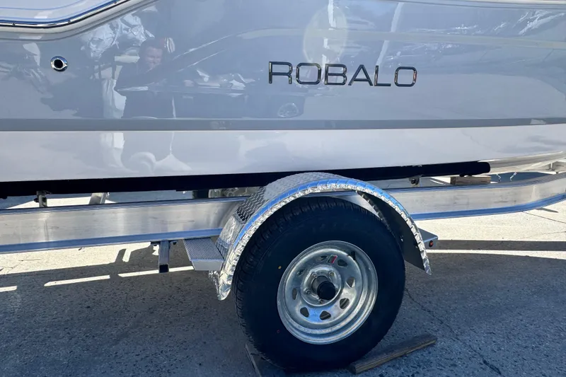 Slide: The Image of 2026 Robalo R160 Center Console boat on trailer, side view with visible wheel. - 8