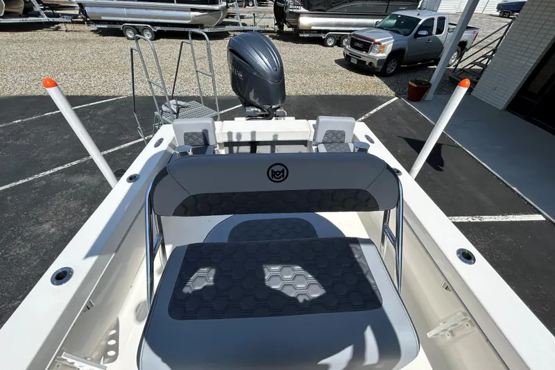 Slide: The Image of 2026 May-Craft 238 Offshore CC boat with seating and outboard motor in a parking lot. - 13