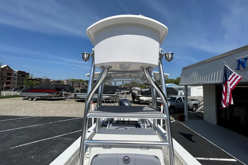 Slide: The Image of 2026 May-Craft 238 Offshore CC boat with T-top, parked outdoors under clear sky. - 18