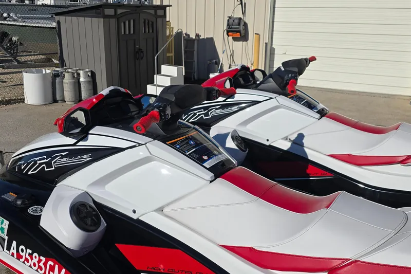 Slide: The Image of 2021 Yamaha WaveRunner VX Deluxe jet skis with red and white seats, parked outdoors. - 5