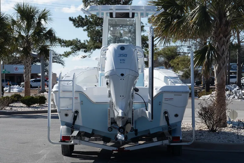 Slide: The Image of 2026 Blazer Bay Makaira 2600 boat with powerful outboard motor, parked under palm trees. - 6