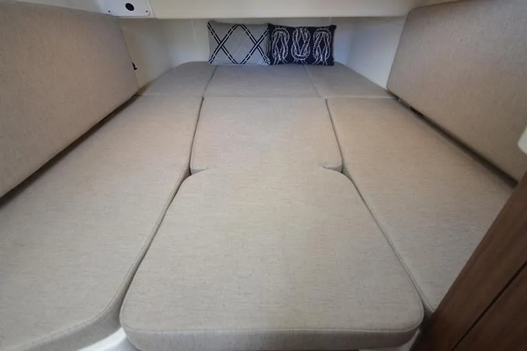 Slide: The Image of Manufacturer Provided Image: 2025 Boston Whaler 380 Outrage cabin interior with beige cushions and decorative pillows. - 16