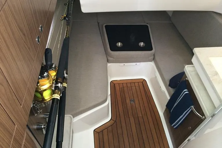 Slide: The Image of Manufacturer Provided Image: 2025 Boston Whaler 380 Outrage cabin interior with wood flooring and fishing rods. - 17