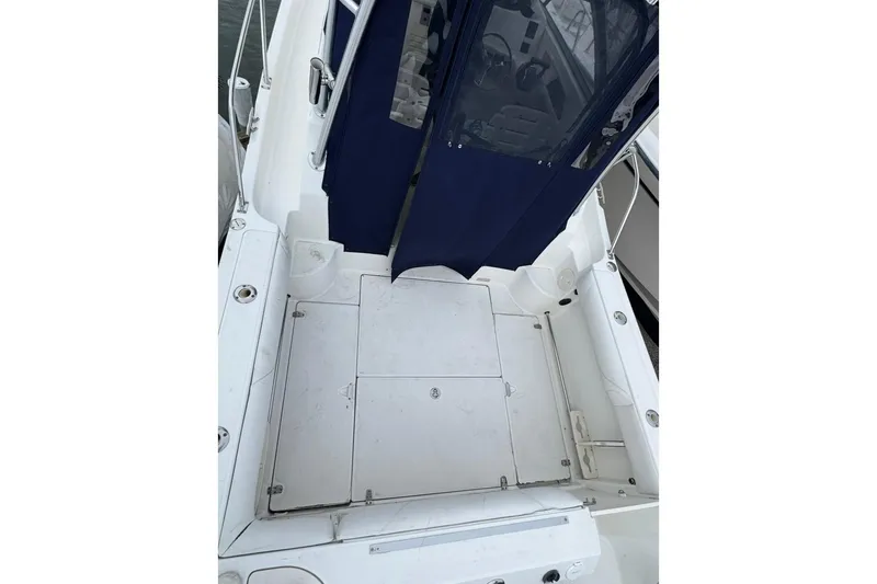 Slide: The Image of 2005 Boston Whaler 255 Conquest boat deck with blue canopy and storage compartments. - 10