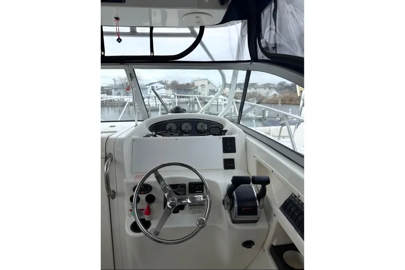 Slide: The Image of 2005 Boston Whaler 255 Conquest boat helm with steering wheel and controls. - 12