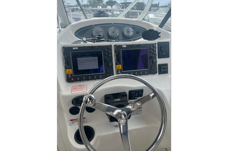 Slide: The Image of 2005 Boston Whaler 255 Conquest helm with dual navigation screens and steering wheel. - 13