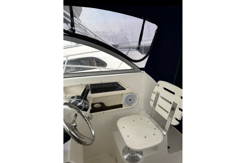 Slide: The Image of 2005 Boston Whaler 255 Conquest helm with steering wheel and captain's chair. - 16