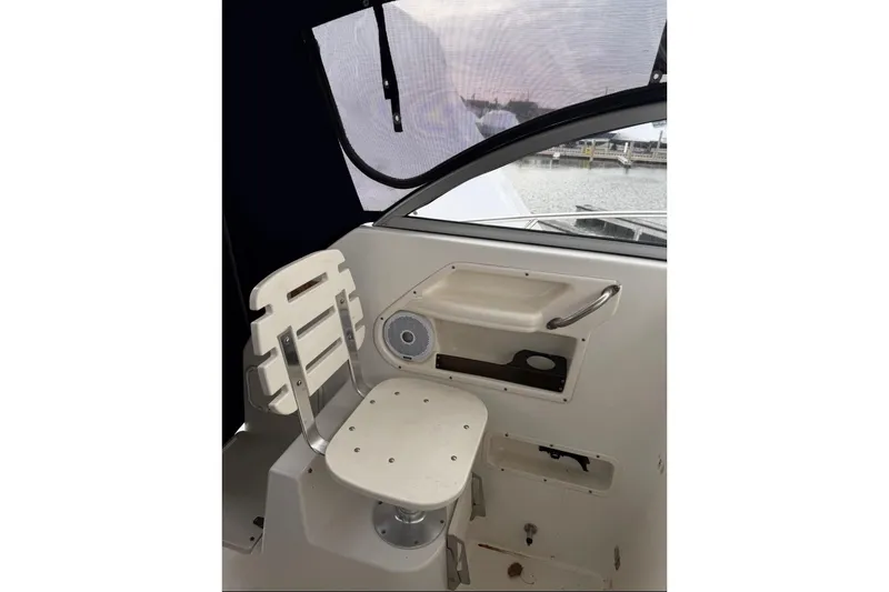 Slide: The Image of Interior of 2005 Boston Whaler 255 Conquest boat, featuring a white seat and storage area. - 17