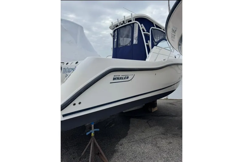 Slide: The Image of 2005 Boston Whaler 255 Conquest boat on a stand, featuring sleek design and blue accents. - 2