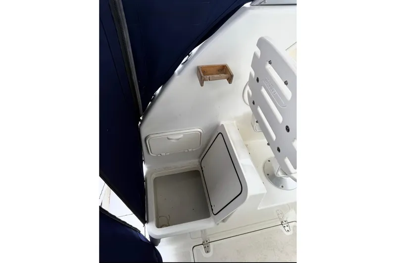 Slide: The Image of 2005 Boston Whaler 255 Conquest interior with storage compartment and seating. - 23