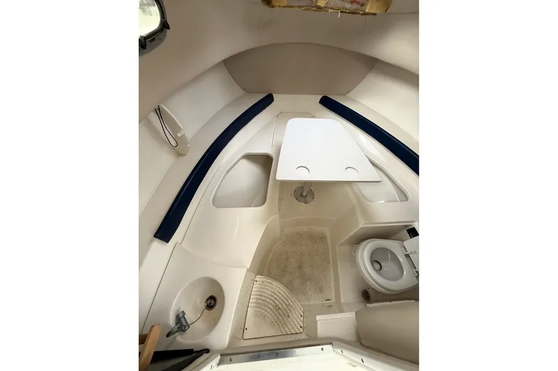 Slide: The Image of 2005 Boston Whaler 255 Conquest cabin interior with table, seating, and compact amenities. - 24