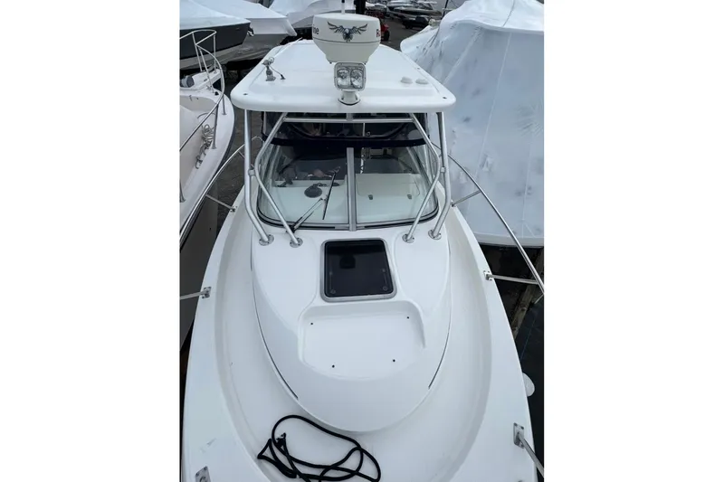 Slide: The Image of 2005 Boston Whaler 255 Conquest boat, white exterior, docked with protective covers. - 3