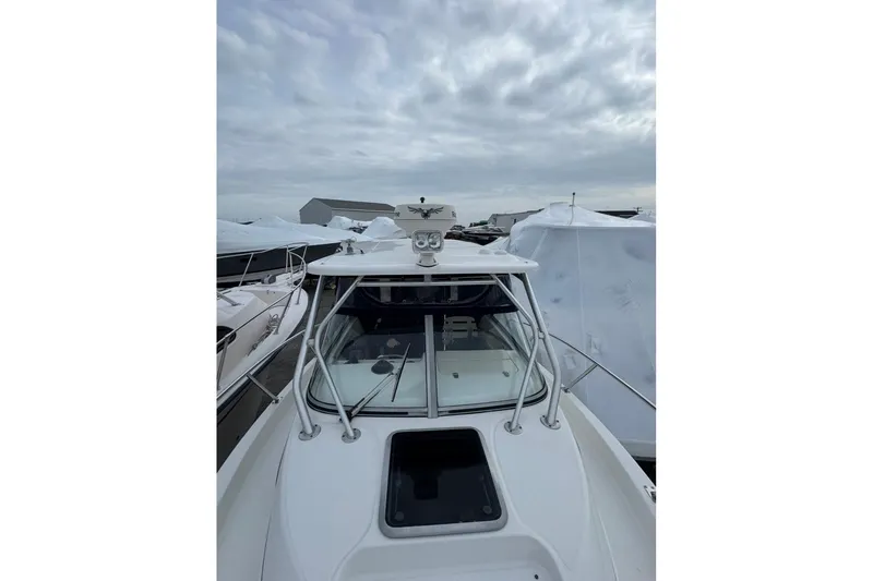 Slide: The Image of 2005 Boston Whaler 255 Conquest boat docked under cloudy skies. - 4