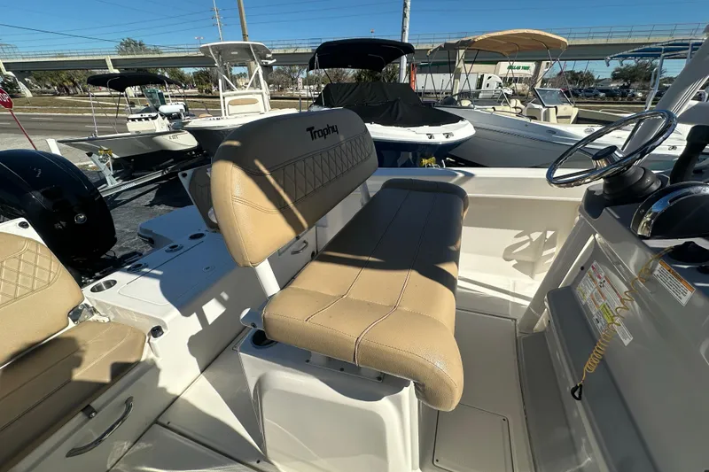 Slide: The Image of 2021 Bayliner Trophy T22CC boat interior with tan seating and steering console. - 14
