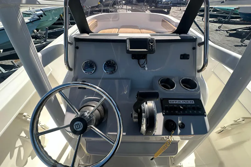 Slide: The Image of 2021 Bayliner Trophy T22CC boat dashboard with steering wheel and controls. - 17
