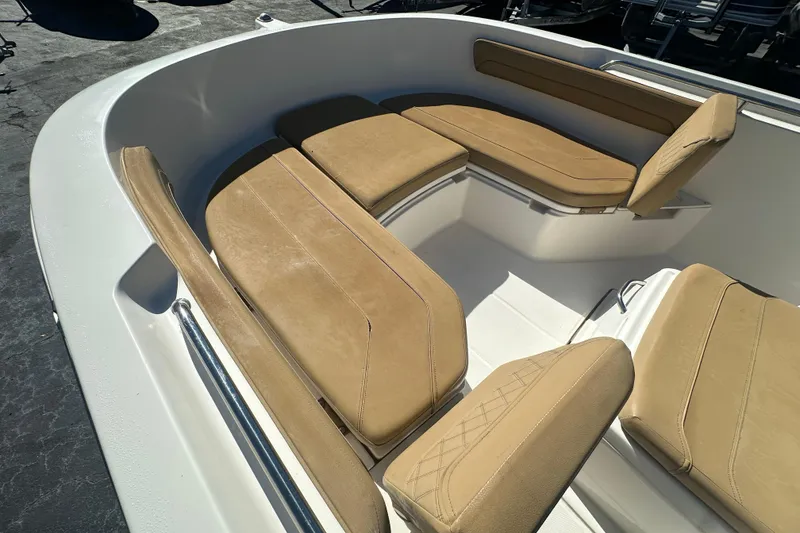 Slide: The Image of 2021 Bayliner Trophy T22CC boat interior with tan cushioned seating. - 23