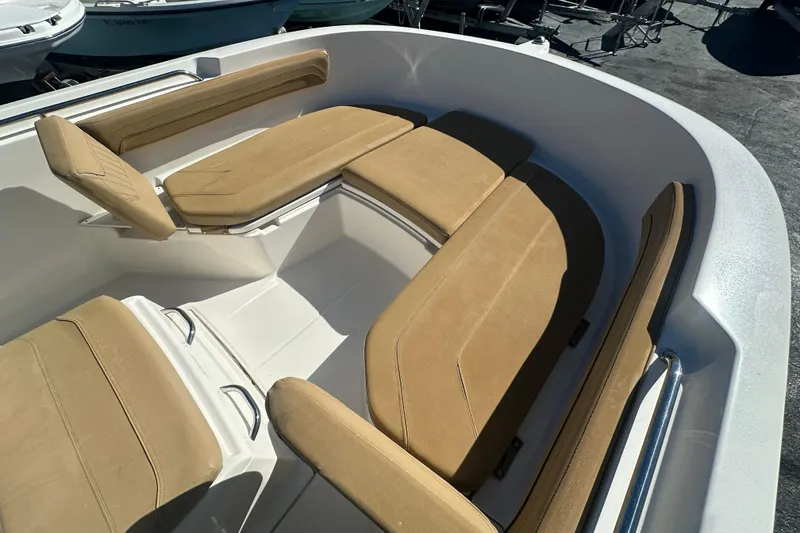 Slide: The Image of 2021 Bayliner Trophy T22CC boat interior with tan cushioned seating. - 25