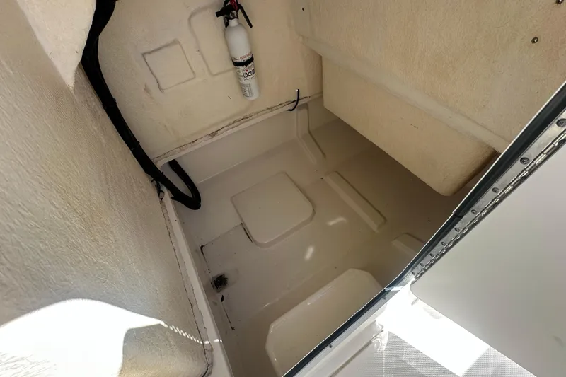 Slide: The Image of 2021 Bayliner Trophy T22CC storage compartment with fire extinguisher, interior view. - 26