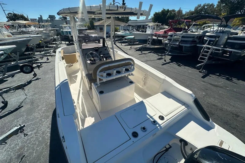 Slide: The Image of 2021 Bayliner Trophy T22CC boat in a marina, showcasing its spacious deck and helm. - 6