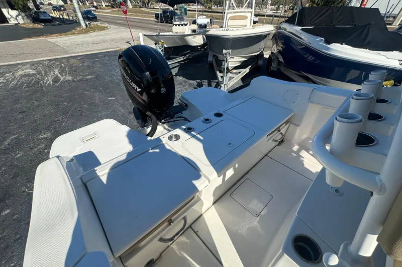 Slide: The Image of 2021 Bayliner Trophy T22CC boat with Mercury engine, featuring spacious deck and rod holders. - 9