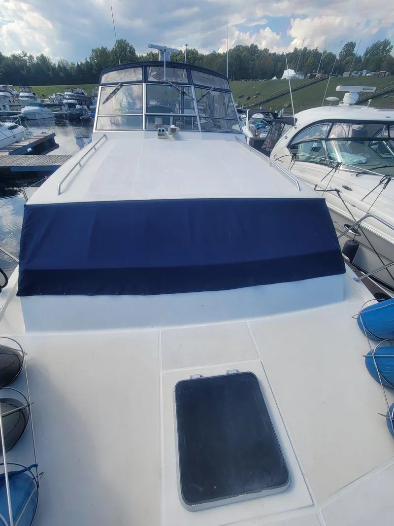 Slide: The Image of 1986 Chris-Craft 381 Catalina yacht docked at marina, blue canopy, clear sky. - 10