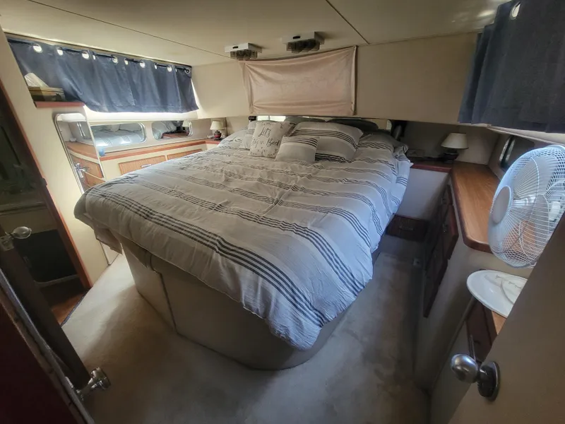 Slide: The Image of Interior of 1986 Chris-Craft 381 Catalina yacht bedroom with striped bedding and cozy decor. - 18