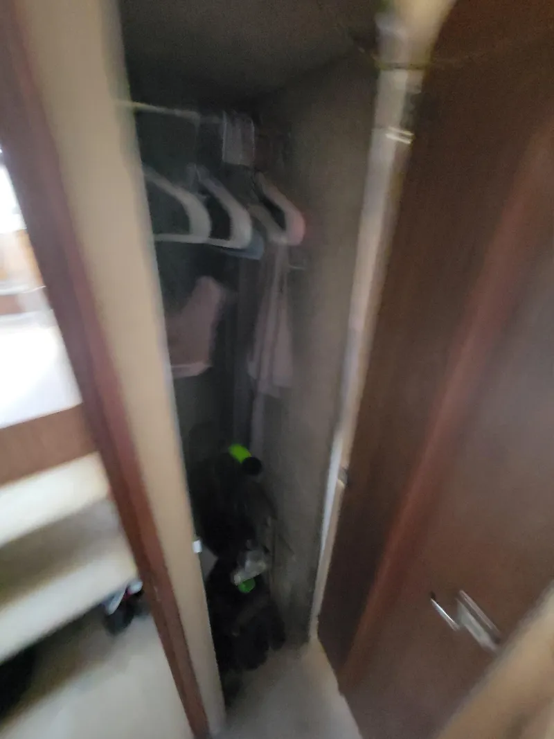 Slide: The Image of Closet interior on 1986 Chris-Craft 381 Catalina yacht with hangers and clothing. - 19
