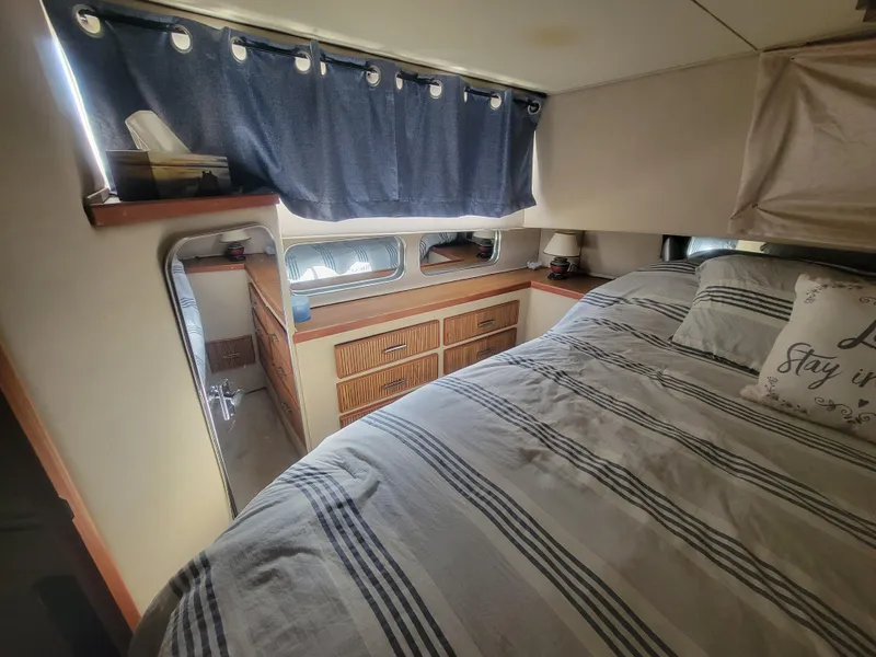 Slide: The Image of Interior of 1986 Chris-Craft 381 Catalina with cozy bed and striped bedding. - 20
