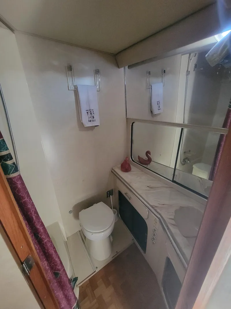 Slide: The Image of 1986 Chris-Craft 381 Catalina bathroom with toilet, sink, and mirror. - 21