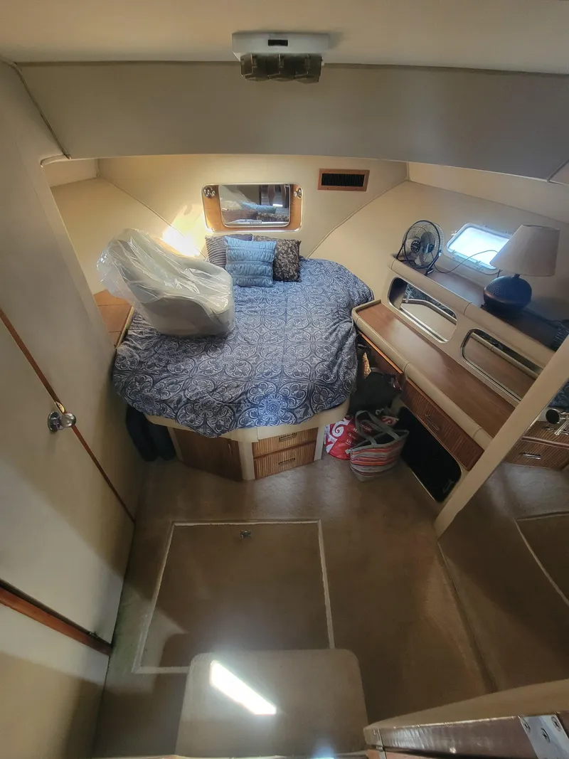 Slide: The Image of 1986 Chris-Craft 381 Catalina cabin interior with bed, storage, and seating area. - 26