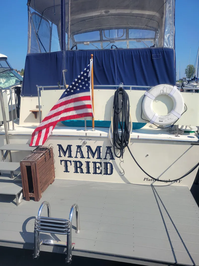 Slide: The Image of 1986 Chris-Craft 381 Catalina boat with "Mama Tried" text, American flag, and dock ladder. - 6